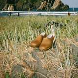 Pair of hemp Gardana clogs on a rock in coastal grasses