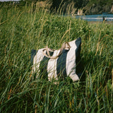 Shore Carryall striped bag standing in coastal grasses